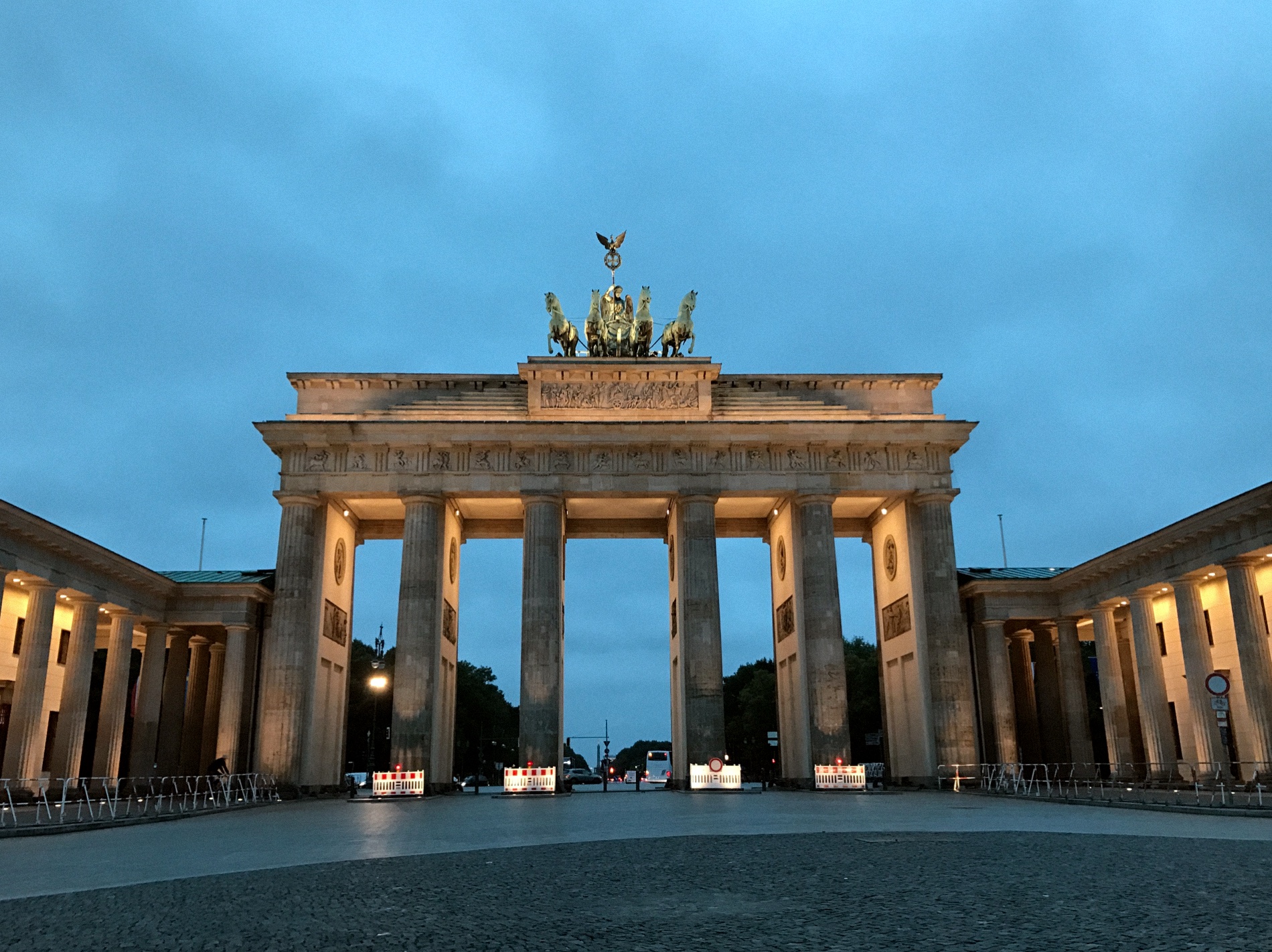 The Brandenburg Gate at blue hour, lit warm against a cool Berlin sky